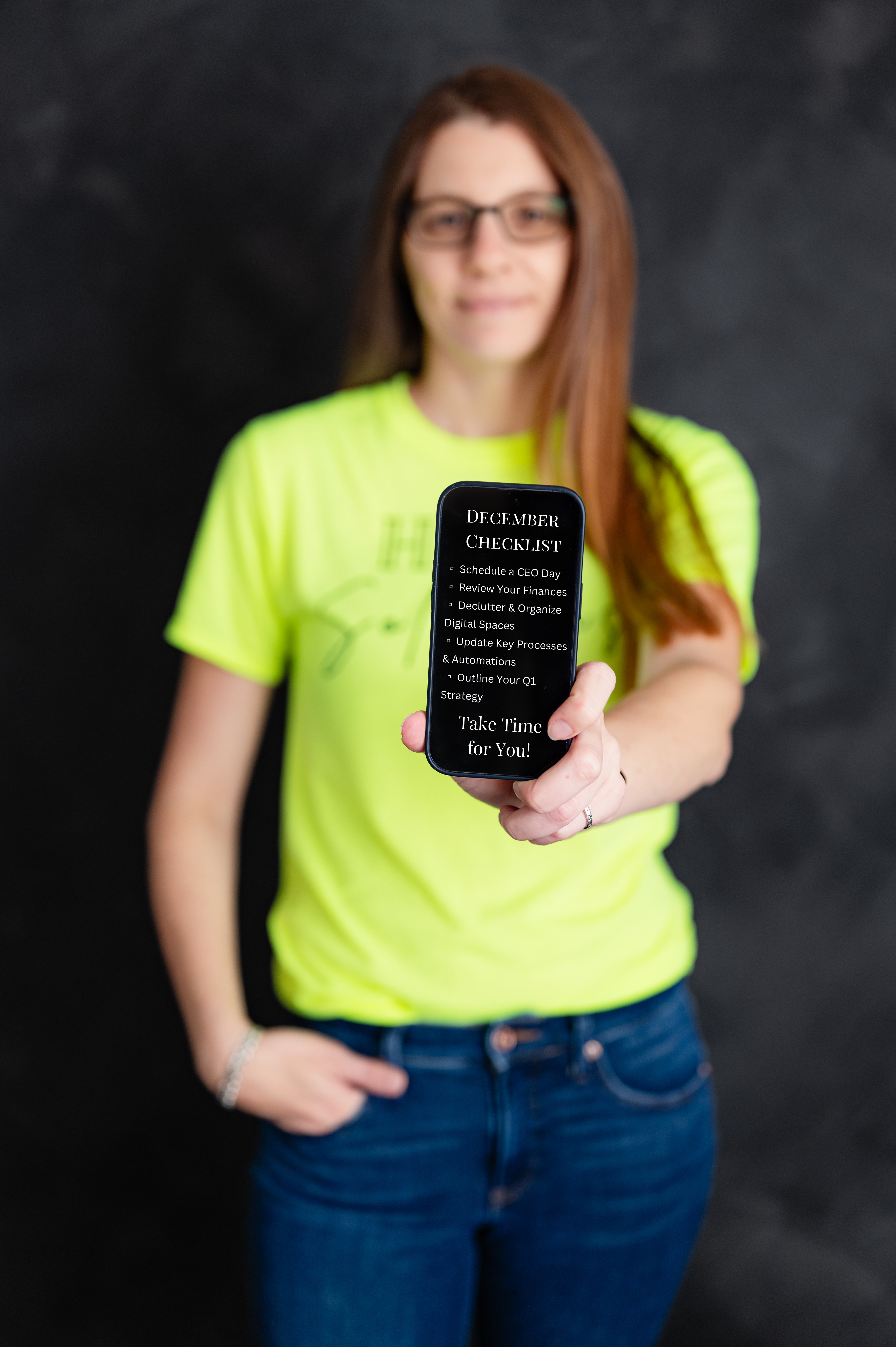 Heather holding a phone showing a December checklist